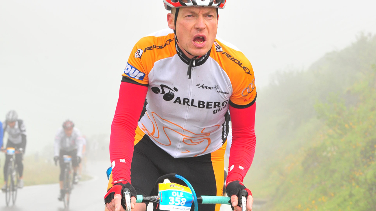 Pastor Ole Dost sits on his racing bike in racing bike gear and takes part in a race.